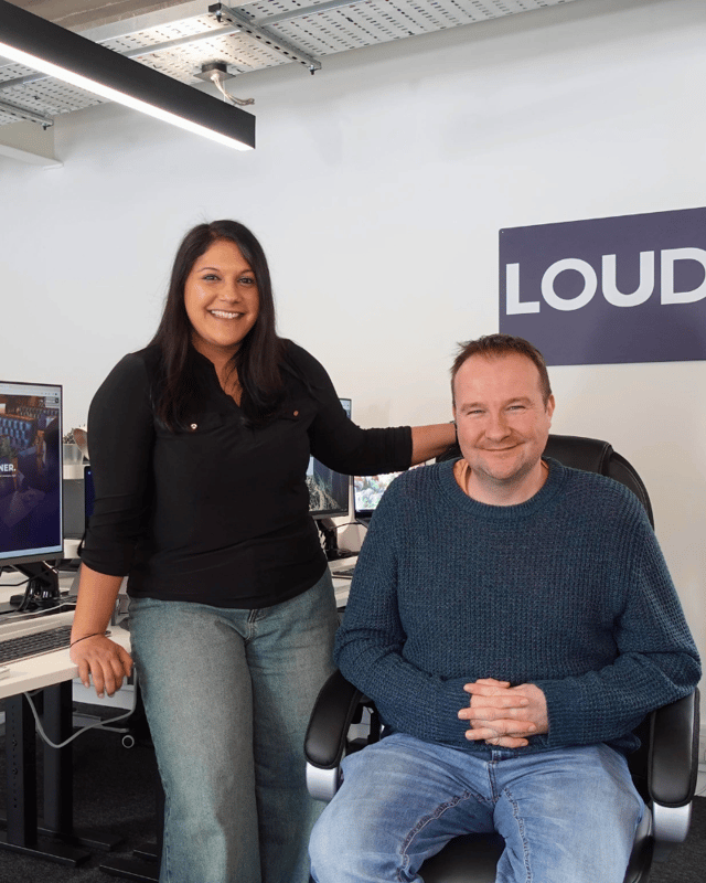 Leon and Priya against the LoudLocal sign