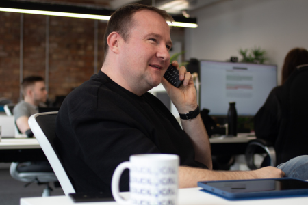 A picture of Leon Hidderley from LoudLocal on the phone to a client in the LoudLocal office