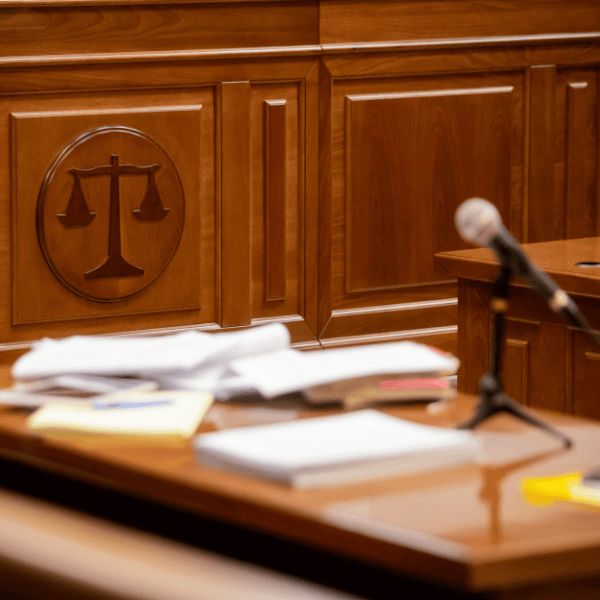 A photo of a court room, focusing on the wall which displays scales which are weighed equally.